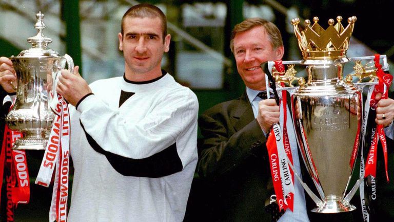 Eric Cantona and Sir Alex Ferguson display the FA Cup and Premiership trophies in 1996