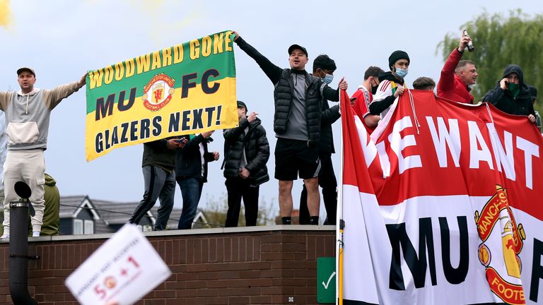 المشجعون يرفعون لافتات أثناء احتجاجهم على عائلة جليزر ، مالكي مانشستر يونايتد ، قبل مباراتهم في الدوري الإنجليزي الممتاز ضد ليفربول على ملعب أولد ترافورد.