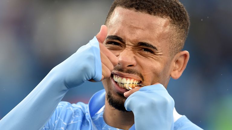 Gabriel Jesus gestures as he bites down on his Premier League winners medal (AP)