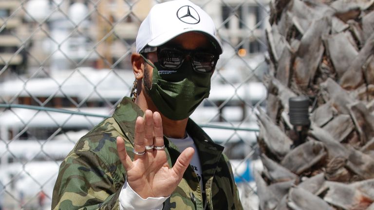 Mercedes driver Lewis Hamilton of Britain waves as he walks in the paddock at the Monaco racetrack, in Monaco, Wednesday, May 19, 2021. The Formula one race will be held on Sunday.