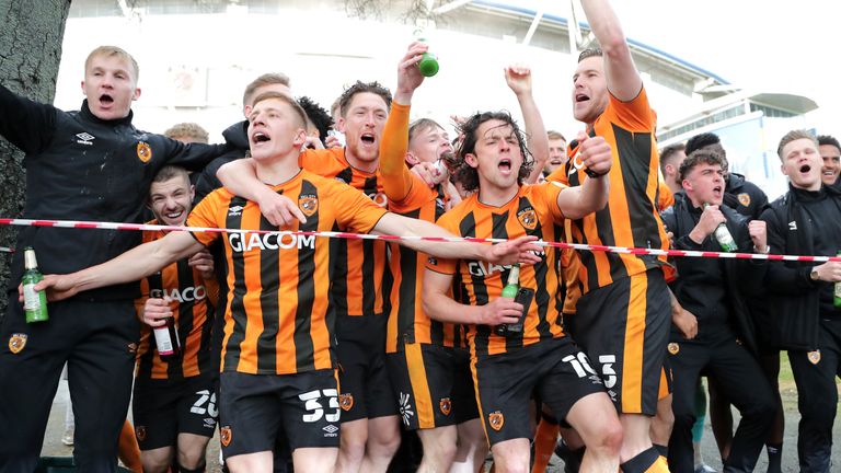 Hull&#39;s players celebrate winning the League One title with fans gathered outside the KCOM Stadium.