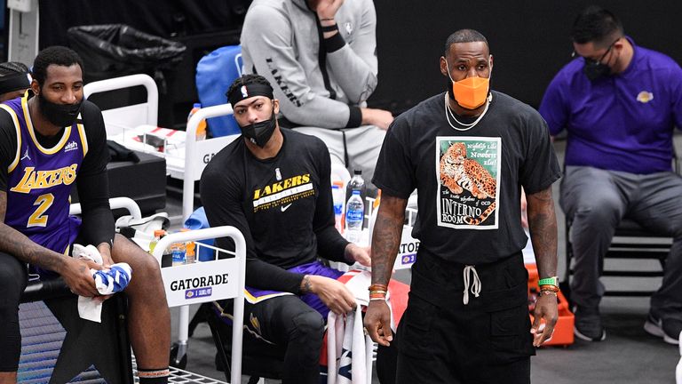 Los Angeles Lakers forward LeBron James, in orange mask, watches during the first half of an NBA basketball game against the Washington Wizards