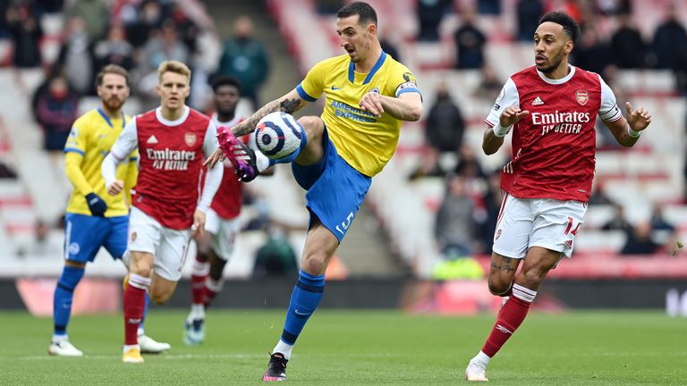 Lewis Dunk clears the ball under pressure from Pierre-Emerick Aubameyang