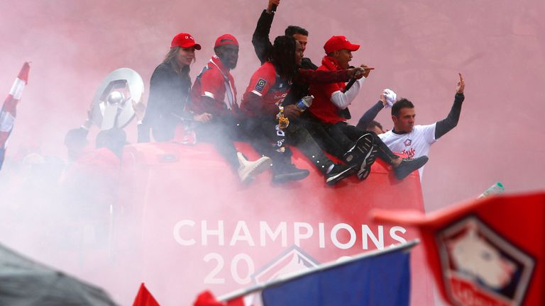 Lille players wave to fans from the top of an open top bus after winning the French League.