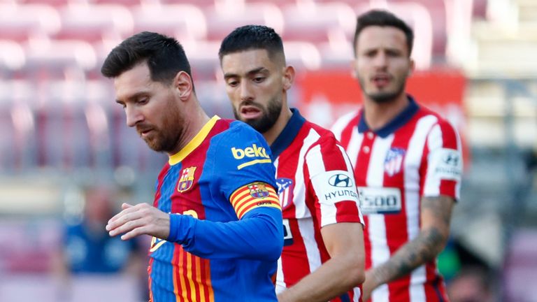 Lionel Messi (à esquerda) do Barcelona passa por Yannick Carrasco do Atlético de Madrid com a bola