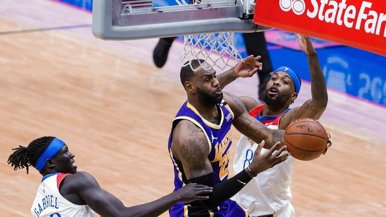 Los Angeles Lakers forward LeBron James (23) drives past New Orleans Pelicans forward Naji Marshall (8) and forward Wenyen Gabriel (32) in the second quarter of an NBA basketball game in New Orleans, Sunday, May 16, 2021. (AP Photo/Derick Hingle)
