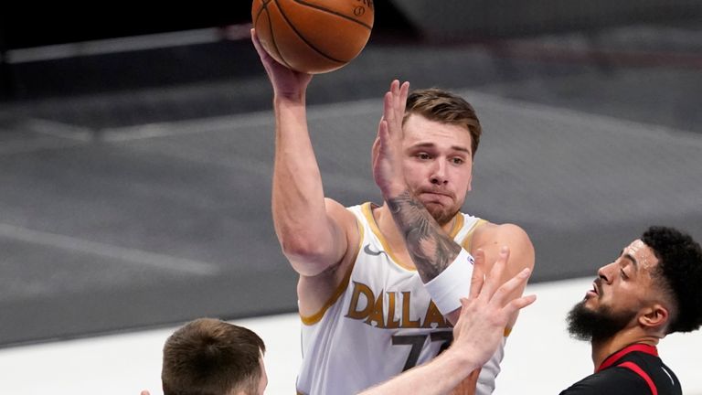 Toronto Raptors' Aron Baynes (46), Jalen Harris (2) and Khem Birch, bottom right, defend as Dallas Mavericks guard Luka Doncic (77) makes a pass in the first half of an NBA basketball game in Dallas, Friday, May 14, 2021. (AP Photo/Tony Gutierrez)