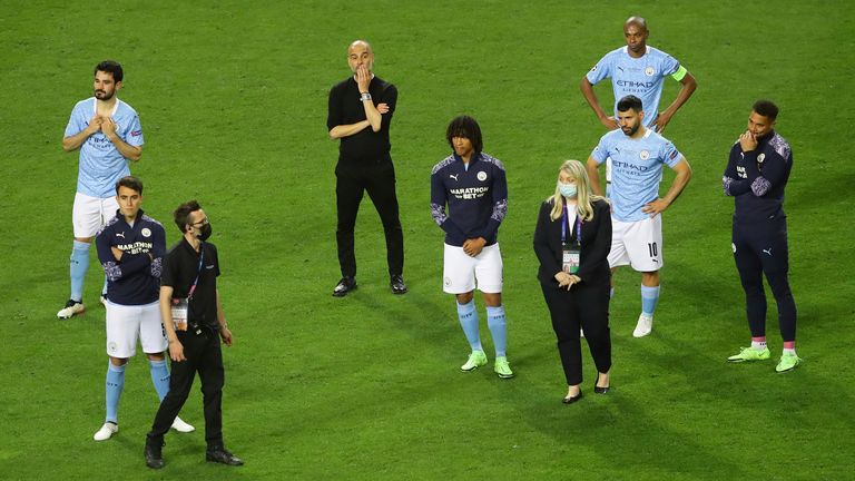 Pep Guardiola stands next to his Manchester City players after their defeat in the Champions League final