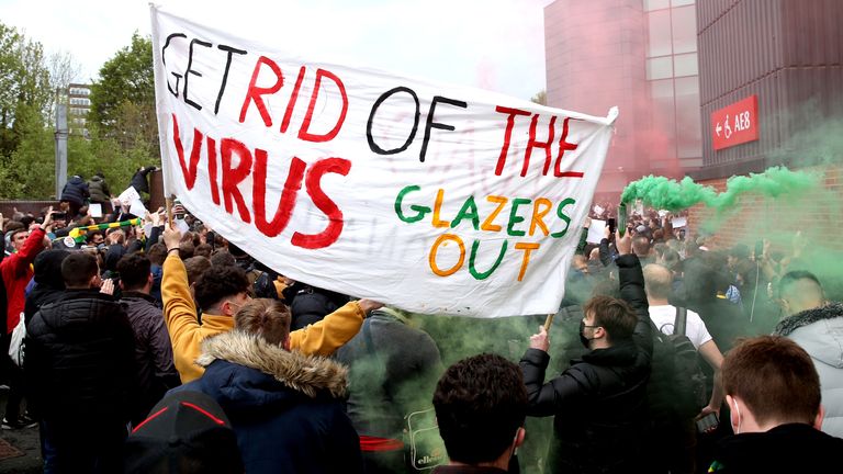 Manchester United fans protest outside of Old Trafford before the game against Liverpool, which was postponed on safety grounds