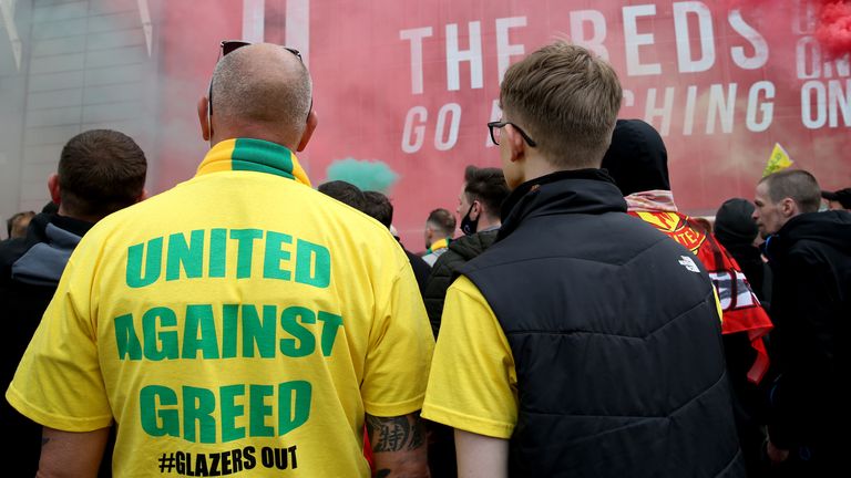 A fan wears a shirt with a "United Against Greed" message on as fans gather to protest against the Glazer family, the owners of Manchester United, before their Premier League match against Liverpool at Old Trafford, Manchester. Issue date: Sunday May 2, 2021