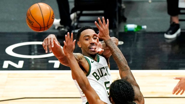 Milwaukee Bucks guard Jeff Teague, top, passes the ball against Chicago Bulls guard Coby White during the first half of an NBA basketball game in Chicago, Friday, April 30, 2021. (AP Photo/Nam Y. Huh)