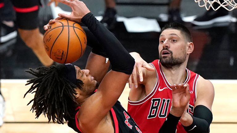 Toronto Raptors forward Freddie Gillespie, left, grabs a rebound next to Chicago Bulls center Nikola Vucevic during the second half of an NBA basketball game in Chicago, Thursday, May 13, 2021. The Bulls won 114-102. 