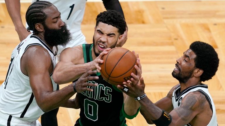 Boston Celtics forward Jayson Tatum (0) drives between Brooklyn Nets guards James Harden, left, and Kyrie Irving during the fourth quarter in Game 3 of an NBA basketball first-round playoff series Friday, May 28, 2021, in Boston.