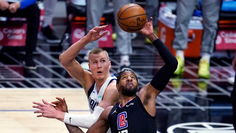 Los Angeles Clippers guard Paul George (13) grabs a rebound next to Dallas Mavericks center Kristaps Porzingis during the first half in Game 2 of an NBA basketball first-round playoff series Tuesday, May 25, 2021, in Los Angeles. (AP Photo/Marcio Jose Sanchez)


