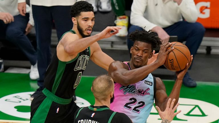 Miami Heat&#39;s Jimmy Butler (22) looks for an opening around Boston Celtics&#39; Jayson Tatum (0) and Boston Celtics&#39; Evan Fournier, below center, in the second half of a basketball game, Sunday, May 9, 2021, in Boston. (AP Photo/Steven Senne)


