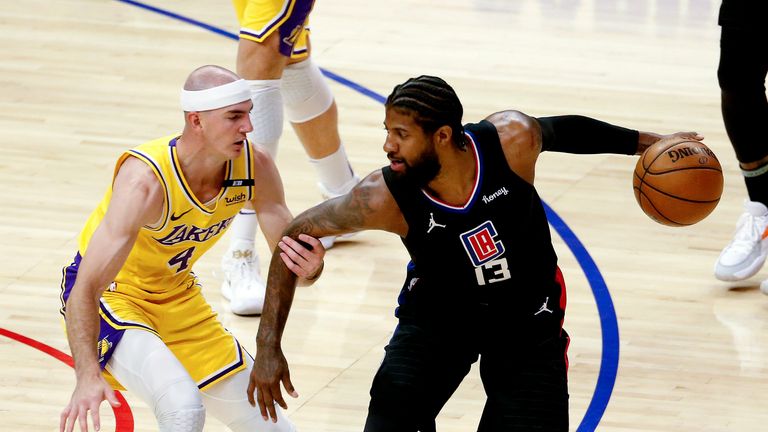 Los Angeles Clippers&#39; Paul George (13) is defended by Los Angeles Lakers&#39; Alex Caruso (4) during the first half of an NBA basketball game Thursday, May 6, 2021, in Los Angeles. (AP Photo/Ringo H.W. Chiu)


