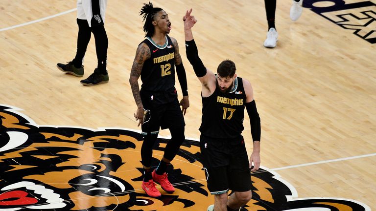 Memphis Grizzlies guard Ja Morant (12) and  center Jonas Valanciunas (17) react in the first half of an NBA basketball Western Conference play-in game against the San Antonio Spurs Wednesday, May 19, 2021, in Memphis, Tenn. (AP Photo/Brandon Dill)