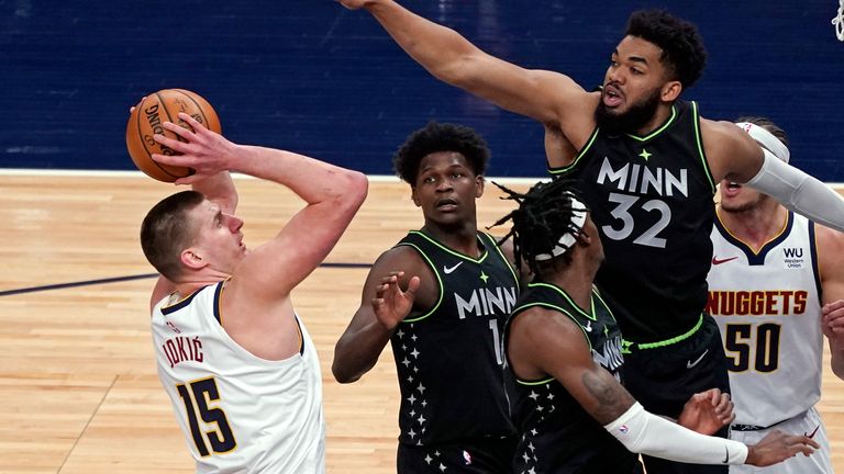 Denver Nuggets&#39; Nikola Jokic (15) shoots as Minnesota Timberwolves&#39; Karl-Anthony Towns (32) defends during the first half of an NBA basketball game Thursday, May 13, 2021, in Minneapolis.