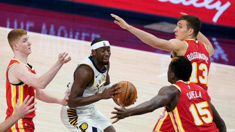 Indiana Pacers&#39; Caris LeVert (22) looks for a shot between Atlanta Hawks&#39; Bogdan Bogdanovic (13), Clint Capela (15) and Kevin Huerter during the second half of an NBA basketball game Thursday, May 6, 2021, in Indianapolis. (AP Photo/Darron Cummings)


