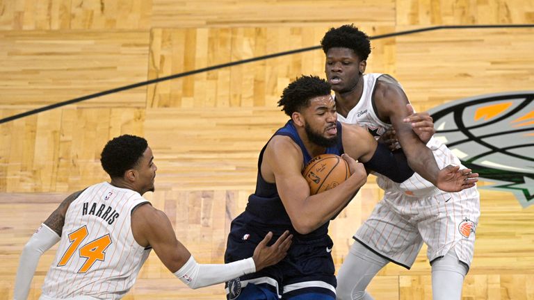 Minnesota Timberwolves center Karl-Anthony Towns drives to the basket between Orlando Magic guard Gary Harris (14) and center Mo Bamba, right, during the first half of an NBA basketball game, Sunday, May 9, 2021, in Orlando, Fla. (AP Photo/Phelan M. Ebenhack)


