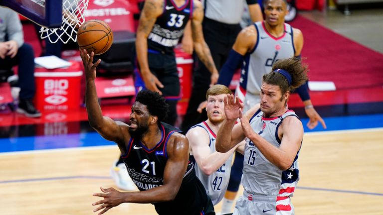 Philadelphia 76ers&#39; Joel Embiid (21) goes up for a shot past Washington Wizards&#39; Davis Bertans (42) and Robin Lopez (15) during the first half of Game 2 in a first-round NBA basketball playoff series, Wednesday, May 26, 2021, in Philadelphia. (AP Photo/Matt Slocum)


