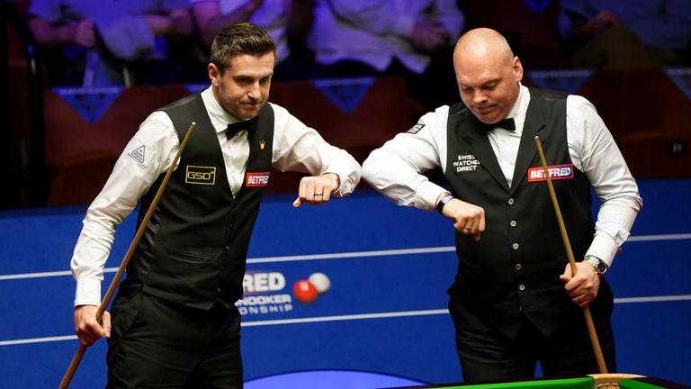 PA - Mark Selby (left) and Stuart Bingham bump elbows during day 13 of the Betfred World Snooker Championships 2021 at The Crucible, Sheffield. 