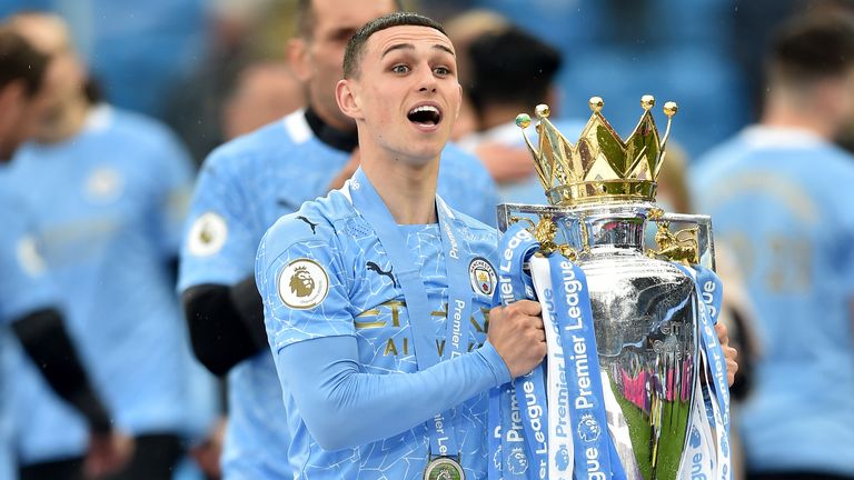 Phil Foden celebrates with the Premier League trophy