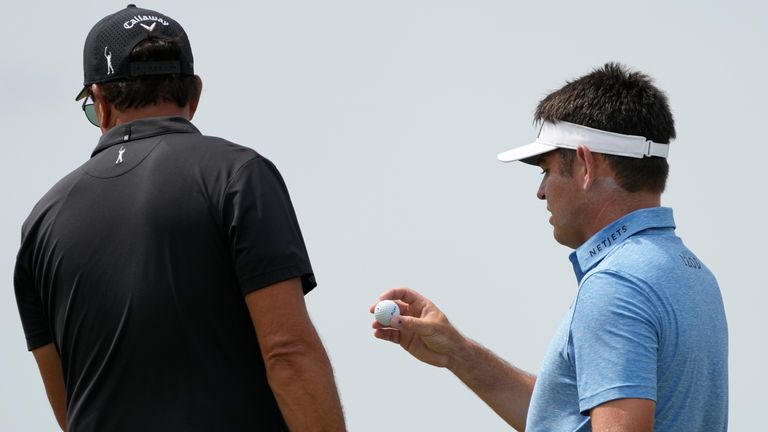 Phil Mickelson, left, speaks with Louis Oosthuizen, of South Africa, on the third green during the third round at the PGA Championship golf tournament on the Ocean Course, Saturday, May 22, 2021, in Kiawah Island, S.C. (AP Photo/David J. Phillip)