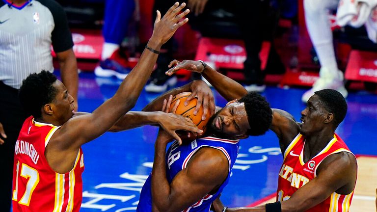 AP - Philadelphia 76ers' Joel Embiid, center, tries to hang onto the ball against Atlanta Hawks' Tony Snell, right, and Onyeka Okongwu