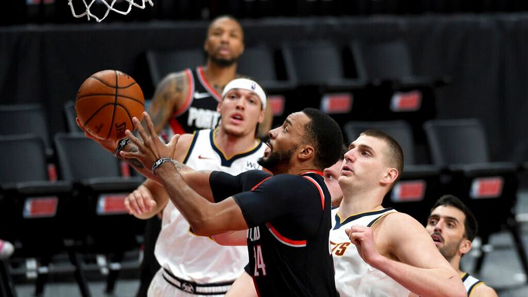 Portland Trail Blazers forward Norman Powell, left, drives to the basket on Denver Nuggets center Nikola Jokic, right, during the second half of Game 4 of an NBA basketball first-round playoff series in Portland, Ore., Saturday, May 29, 2021. The Blazers won 1115-95. (AP Photo/Steve Dykes)