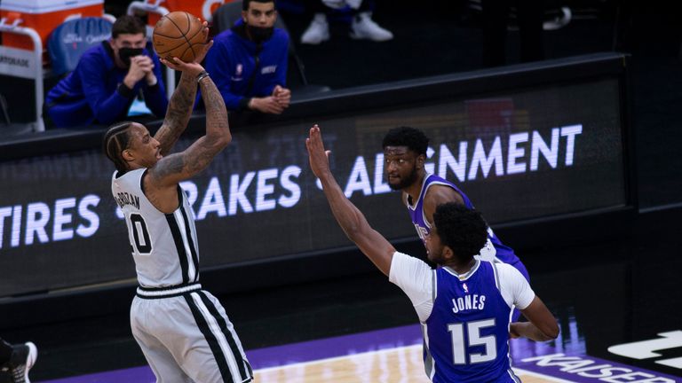 San Antonio Spurs forward DeMar DeRozan shoots the ball as he&#39;s defended by Sacramento Kings center Damian Jones 