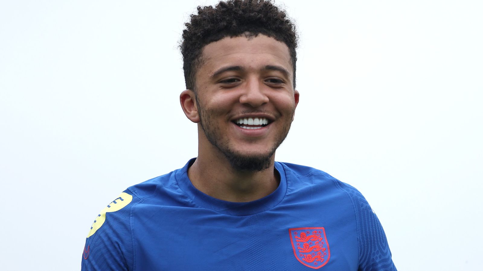 Jadon Sancho smiling in an England training kit