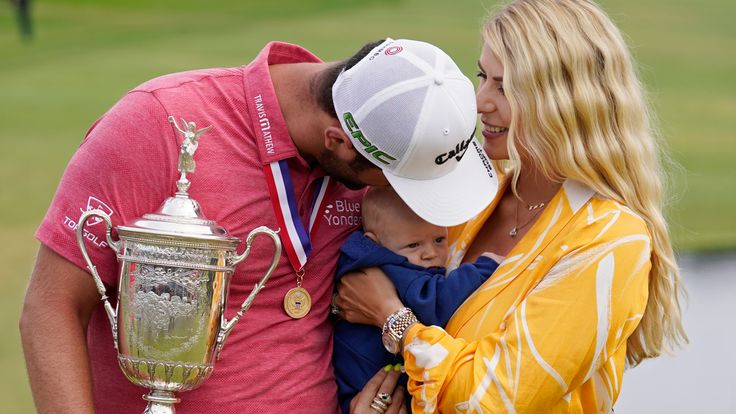 Jon Rahm, of Spain, holds the champions trophy for photographers as he stands with his wife, Kelley Rahm and kisses their child, Kepa Rahm, 11 months, after the final round of the U.S. Open Golf Championship, Sunday, June 20, 2021, at Torrey Pines Golf Course in San Diego.  (AP Photo/Marcio Jose Sanchez)