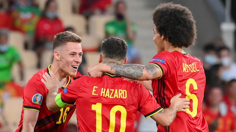 Belgium's Thorgan Hazard celebrates with team-mate's Eden Hazard and Axel Witsel after scoring his team's first goal during the Euro 2020 soccer championship round of 16 match between Belgium and Portugal at La Cartuja stadium, Seville,