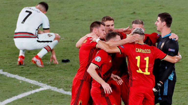 Belgium players celebrate while Cristiano Ronaldo shows his dejection