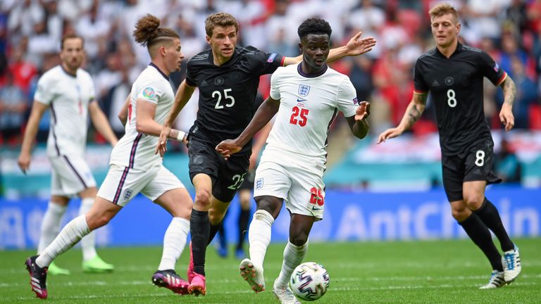 England's Bukayo Saka goes for the ball ahead of Germany's Thomas Mueller during the Euro 2020 soccer championship round of 16 match between England and Germany, at Wembley stadium in London, Tuesday, June 29, 2021. (Andy Rain, Pool via AP)
