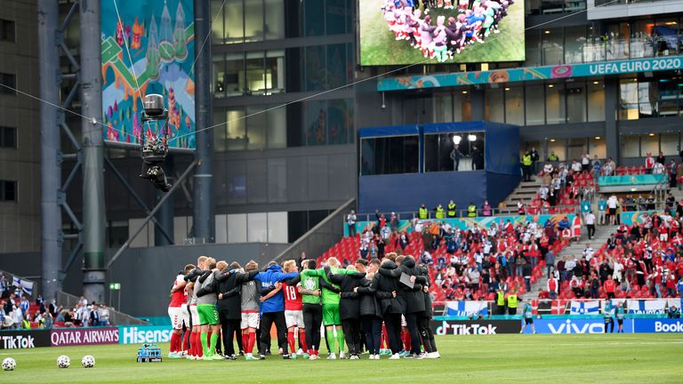 Denmark players gather together on the pitch as they return to resume the match