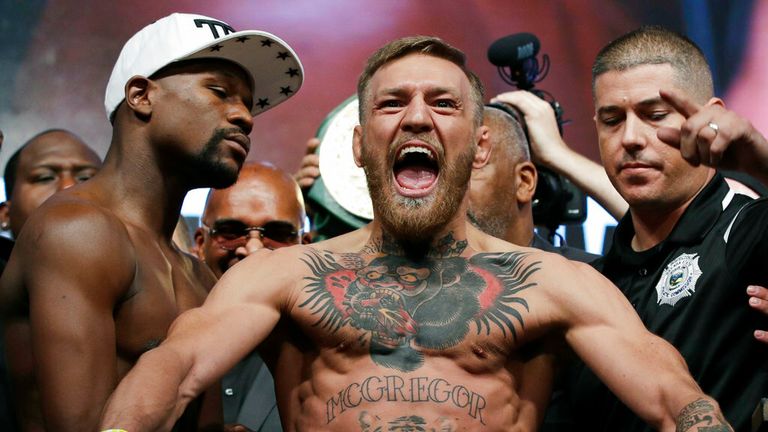 Conor McGregor, center, stands next to Floyd Mayweather Jr., center left, during their weigh-in on Aug. 25, 2017, the day before their boxing match in Las Vegas. (AP Photo/John Locher)