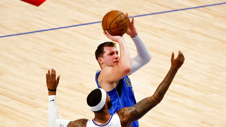Dallas Mavericks guard Luka Doncic, top, shoots a three-point basket in front of Los Angeles Clippers forward Marcus Morris Sr., bottom, in the first half during Game 6 of an NBA basketball first-round playoff series in Dallas, Friday, June 4, 2021. (AP Photo/Michael Ainsworth)