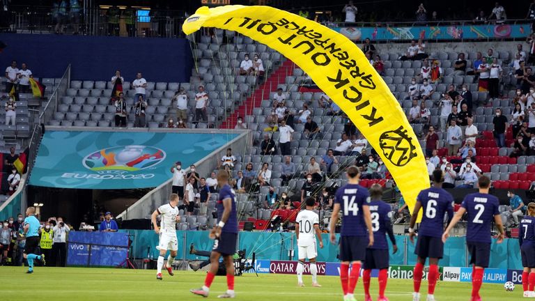A Greenpeace protester paraglides onto the pitch before France's Euro 2020 match with Germany (AP) 