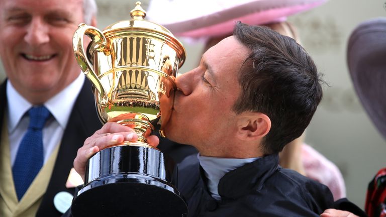 Jockey Frankie Dettori celebrates with the trophy after winning the Gold Cup on Stradivarius during day three of Royal Ascot