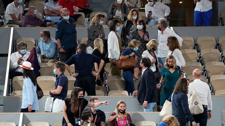Spectators leave to respect the 11pm curfew due to the COVID-19 pandemic during Novak Djokovic's quarter-final match against Matteo Berrettini. (AP Photo/Michel Euler)
