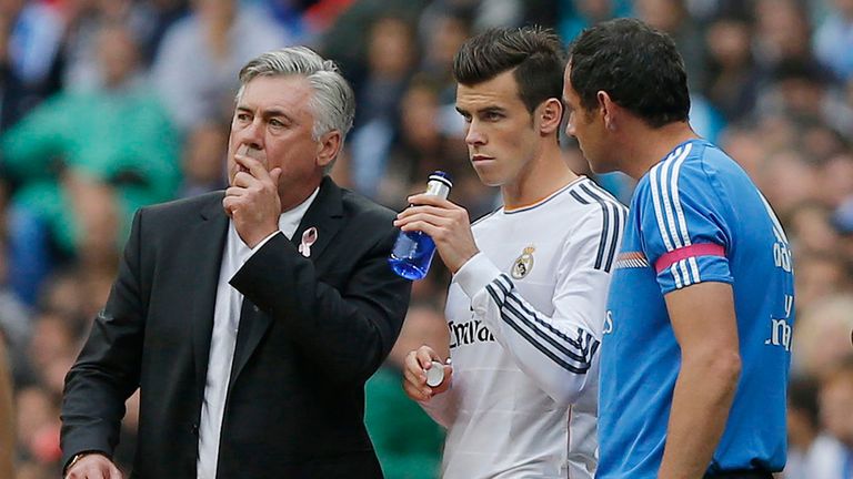 Real Madrid&#39;s Gareth Bale, centre, listens to coach Carlo Ancelotti, left, during a Spanish La Liga soccer match against Malaga at the Santiago Bernabeu stadium in Madrid, Spain, Saturday, Oct. 19, 2013.