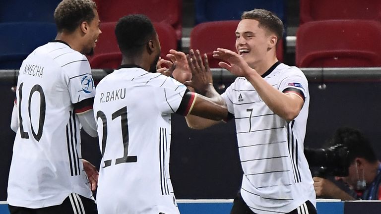 Florian Wirtz (R) celebrates with teammates Germany's forward Lukas Nmecha and Germany's defender Ridle Baku
