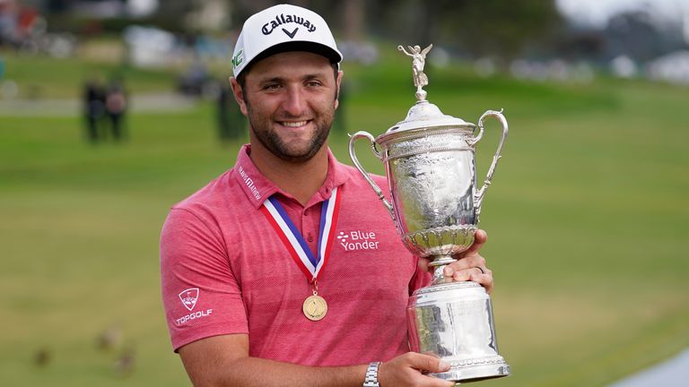 Jon Rahm, of Spain, holds the champions trophy for photographers after the final round of the US Open 