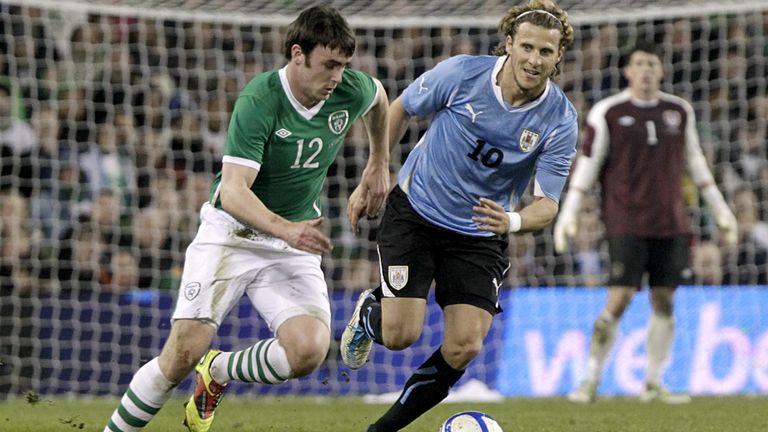 Keith Treacy runs with the ball for Republic of Ireland as Diego Forlan of Uruguay looks on