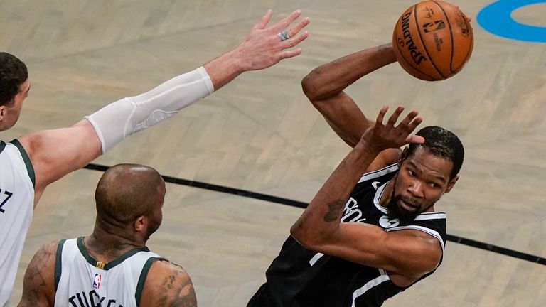 Brooklyn Nets&#39; Kevin Durant, right, passes away from Milwaukee Bucks&#39; P.J. Tucker and Brook Lopez during the first half of Game 7 of a second-round NBA basketball playoff series Saturday, June 19, 2021, in New York. (AP Photo/Frank Franklin II)