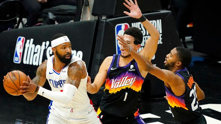 Los Angeles Clippers forward Marcus Morris Sr. looks to pass under pressure from Phoenix Suns guard Devin Booker (1) and forward Mikal Bridges, right, during the first half of game 5 of the NBA basketball Western Conference Finals, Monday, June 28, 2021, in Phoenix. (AP Photo/Matt York)