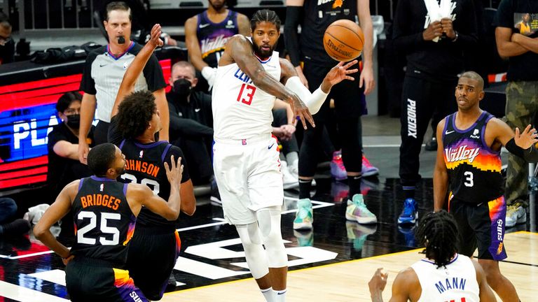 Los Angeles Clippers guard Paul George (13) passes as Phoenix Suns forward Cameron Johnson (23) looks on during the first half of game 5 of the NBA basketball Western Conference Finals, Monday, June 28, 2021, in Phoenix. (AP Photo/Matt York)