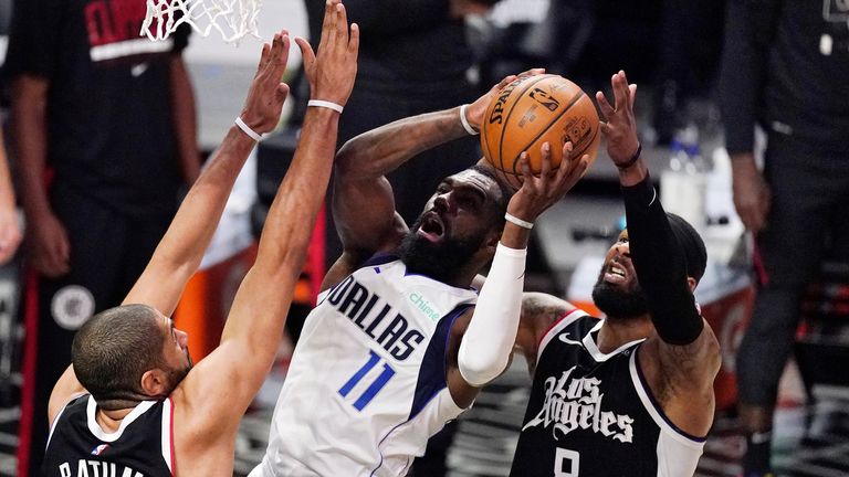 Dallas Mavericks forward Tim Hardaway Jr., center, shoots as Los Angeles Clippers forward Nicolas Batum, left, and forward Marcus Morris Sr. defend during the second half in Game 5 of an NBA basketball first-round playoff series Wednesday, June 2, 2021, in Los Angeles.